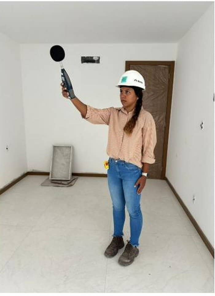 Engenheira da Nortuz utilizando sonômetro para medição acústica em ambiente da edificação